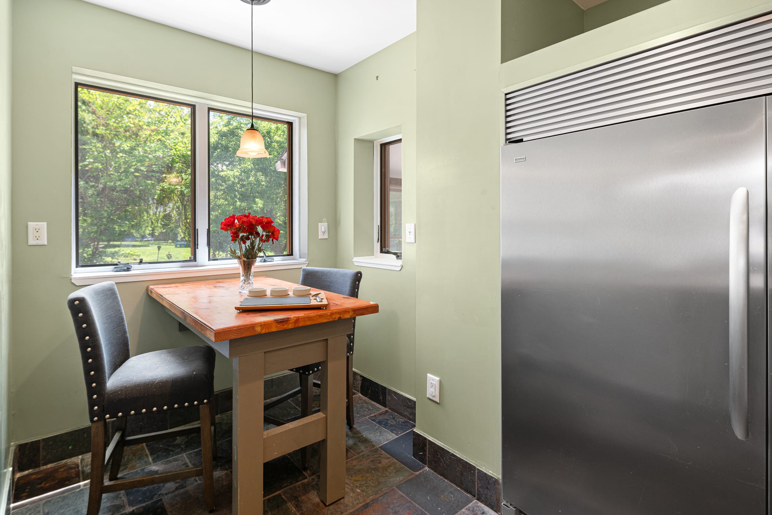 Bright breakfast nook beside pro fridge