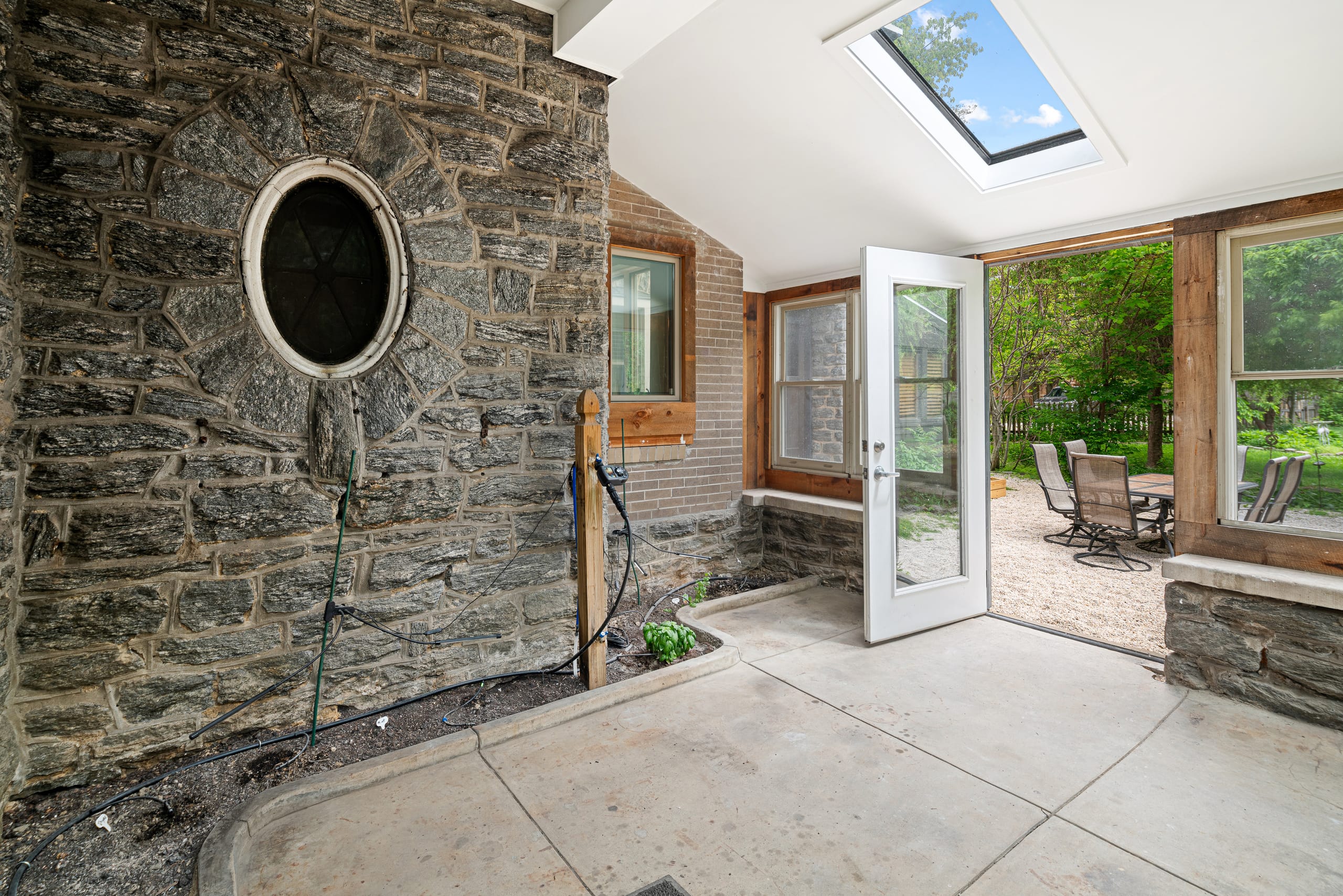 Solarium with stone wall, porthole window and skylight