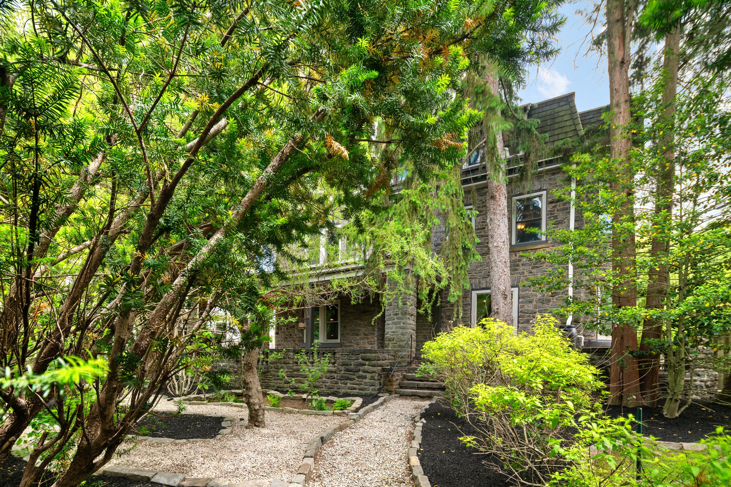Landscaped garden path leading to the stone home